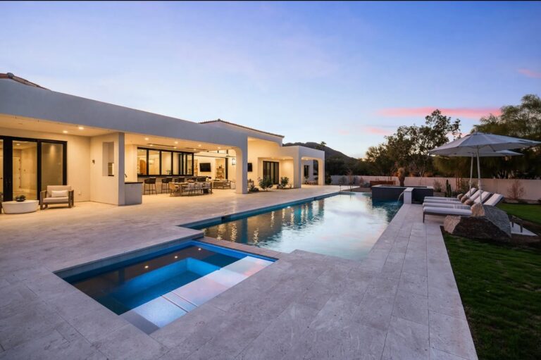 Luxury covered patio with modern outdoor seating, ceiling fan, and open view into a contemporary living room in a CJS Lifestyle custom home.