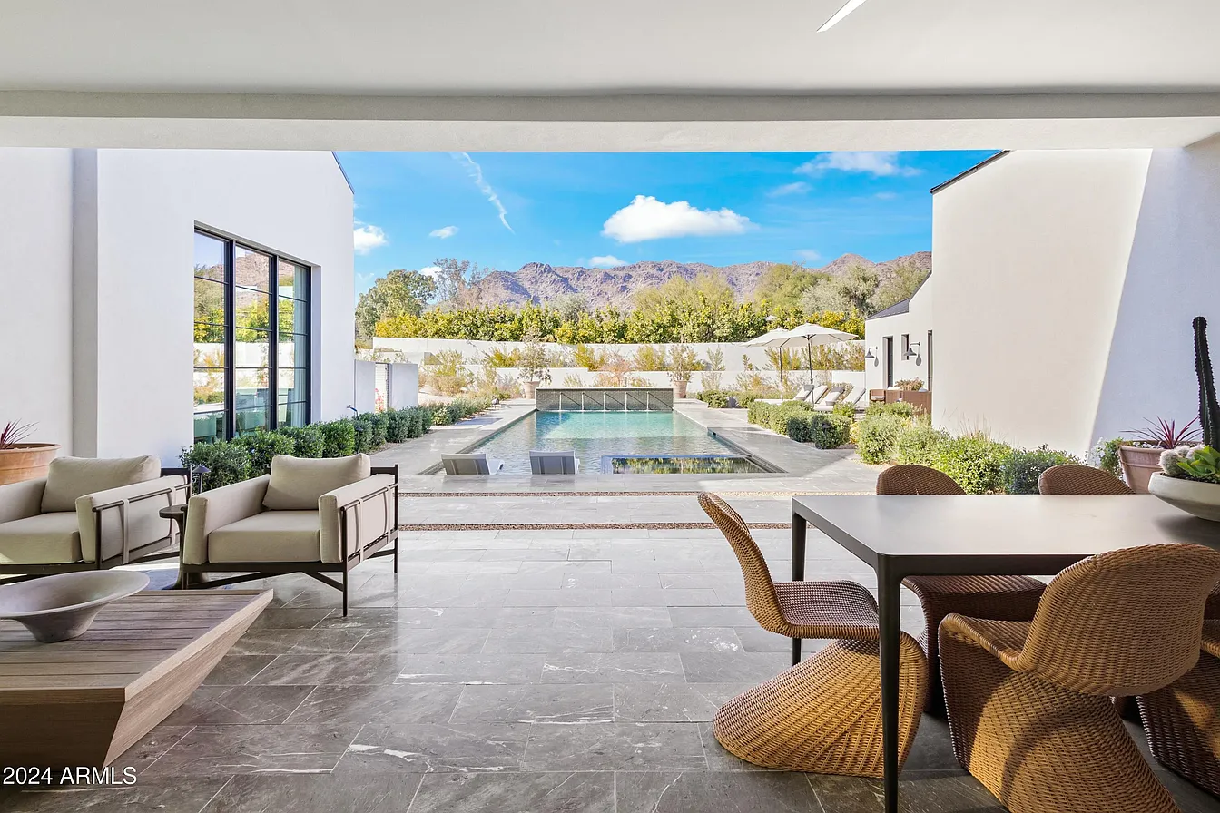 A modern white house with pool and set of table and chairs