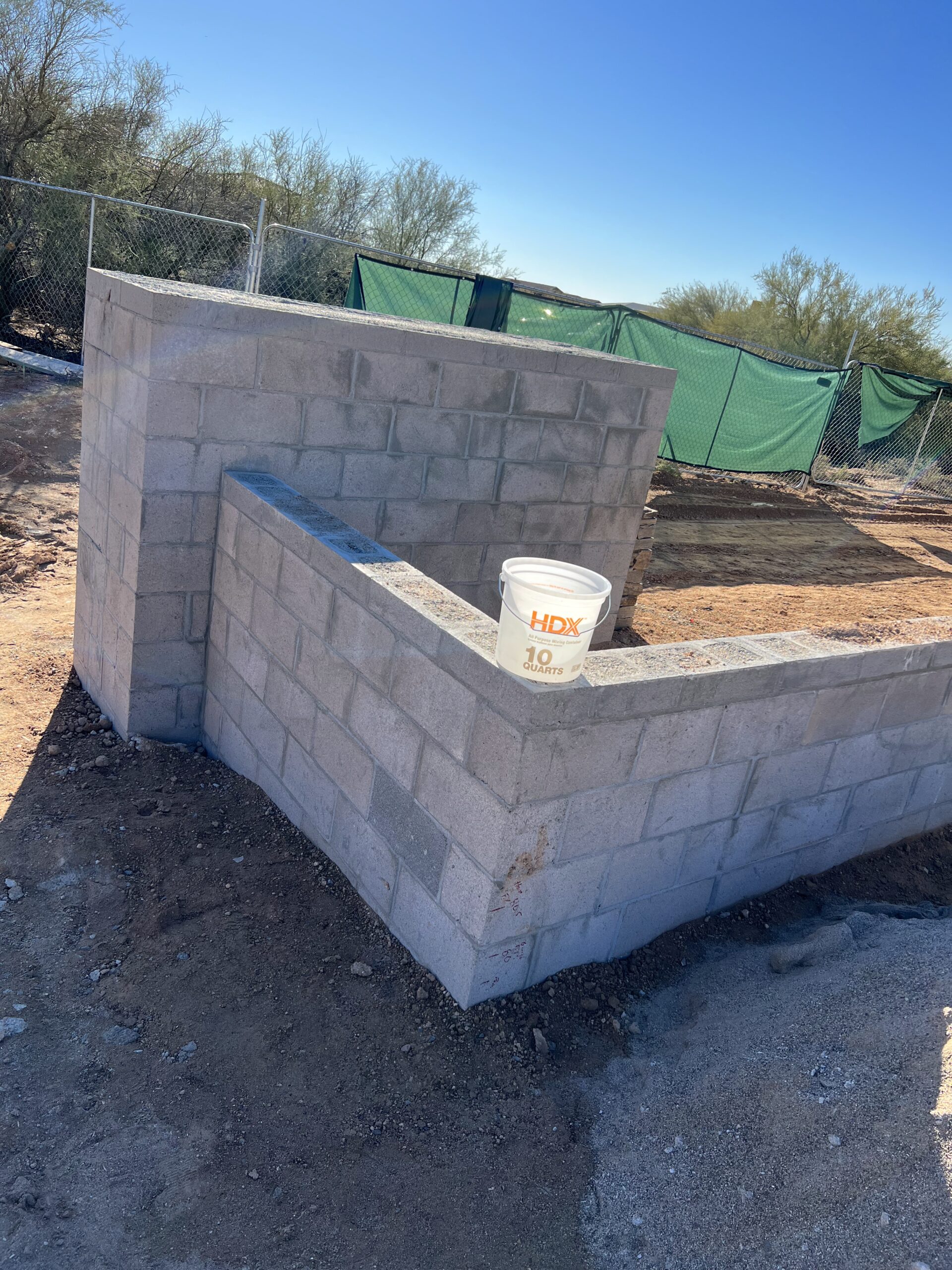 Angled front view of a luxury desert home showcasing stone columns, cactus gardens, and expansive desert surroundings.