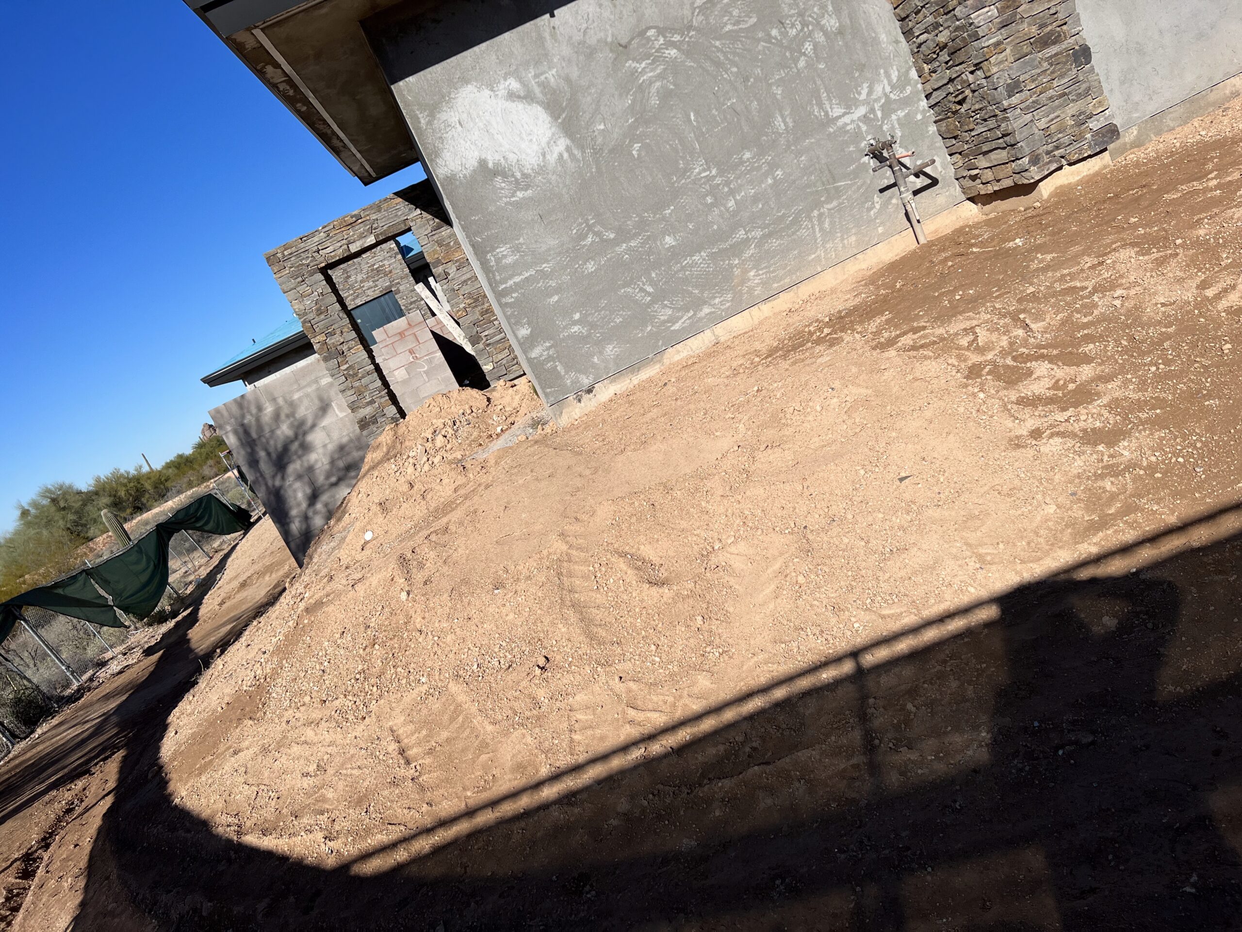 Aerial perspective showing the scale of a modern desert estate, large pool, and surrounding desert neighborhood.