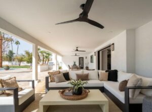 Patio with sofas, fans, and pool view