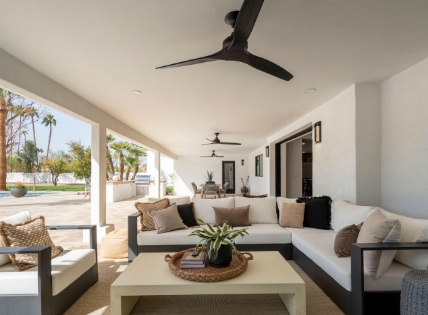 Patio with sofas, fans, and pool view