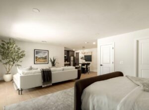 Open space with bed, sofa, plants, and kitchen-dining area