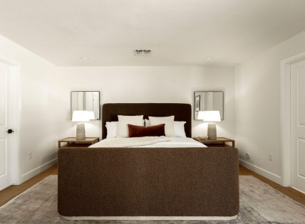 A minimal bedroom with a brown bed, white bedding, matching nightstands, lamps, and mirrors