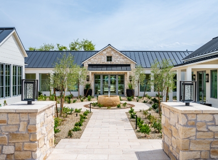 Stone-accented home with a courtyard, central fountain, and landscaped entry